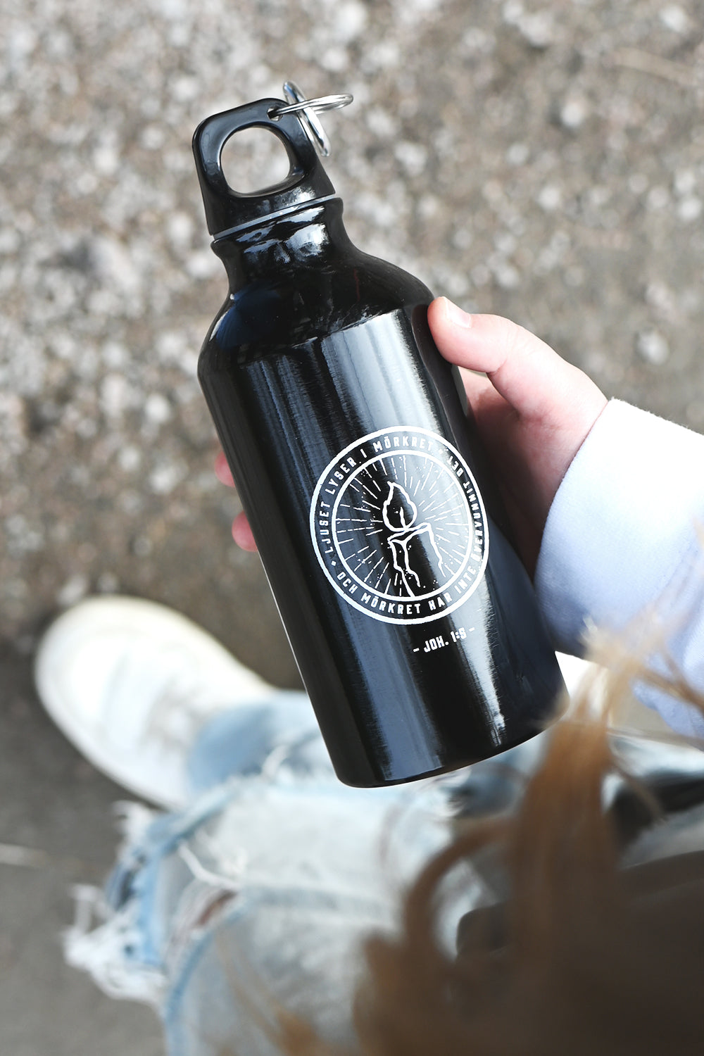 Flaska i svart med vitt tryck: Ljuset lyser