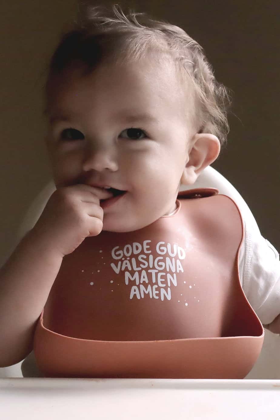 Tegelfärgad, mjuk haklapp i silikon: Gode Gud välsigna maten, amen