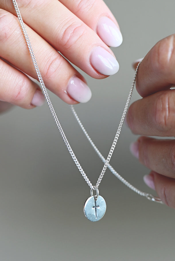 Handtillverkat silversmycke: Kors på rund platta